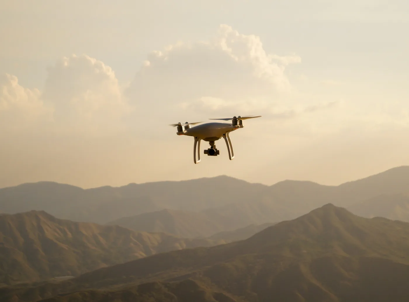 Drone hovering over hazy mountain ridges at dusk
