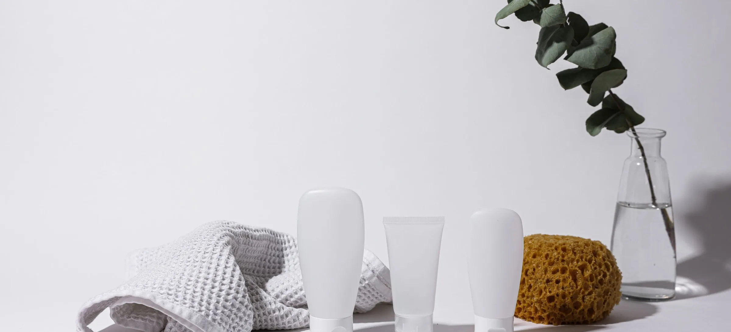 White bottles, towel and sponge in a calm spa setting