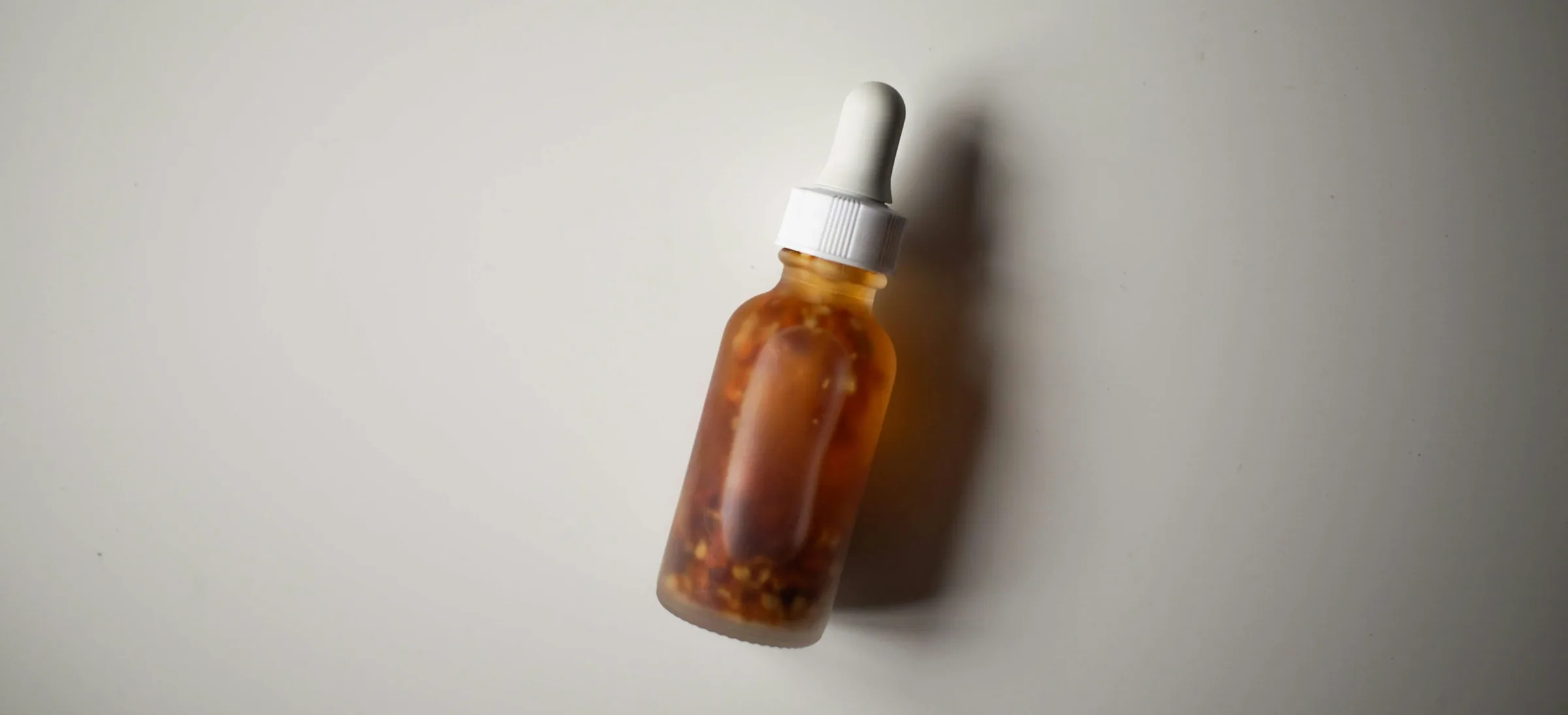 Amber serum bottle on a pale surface